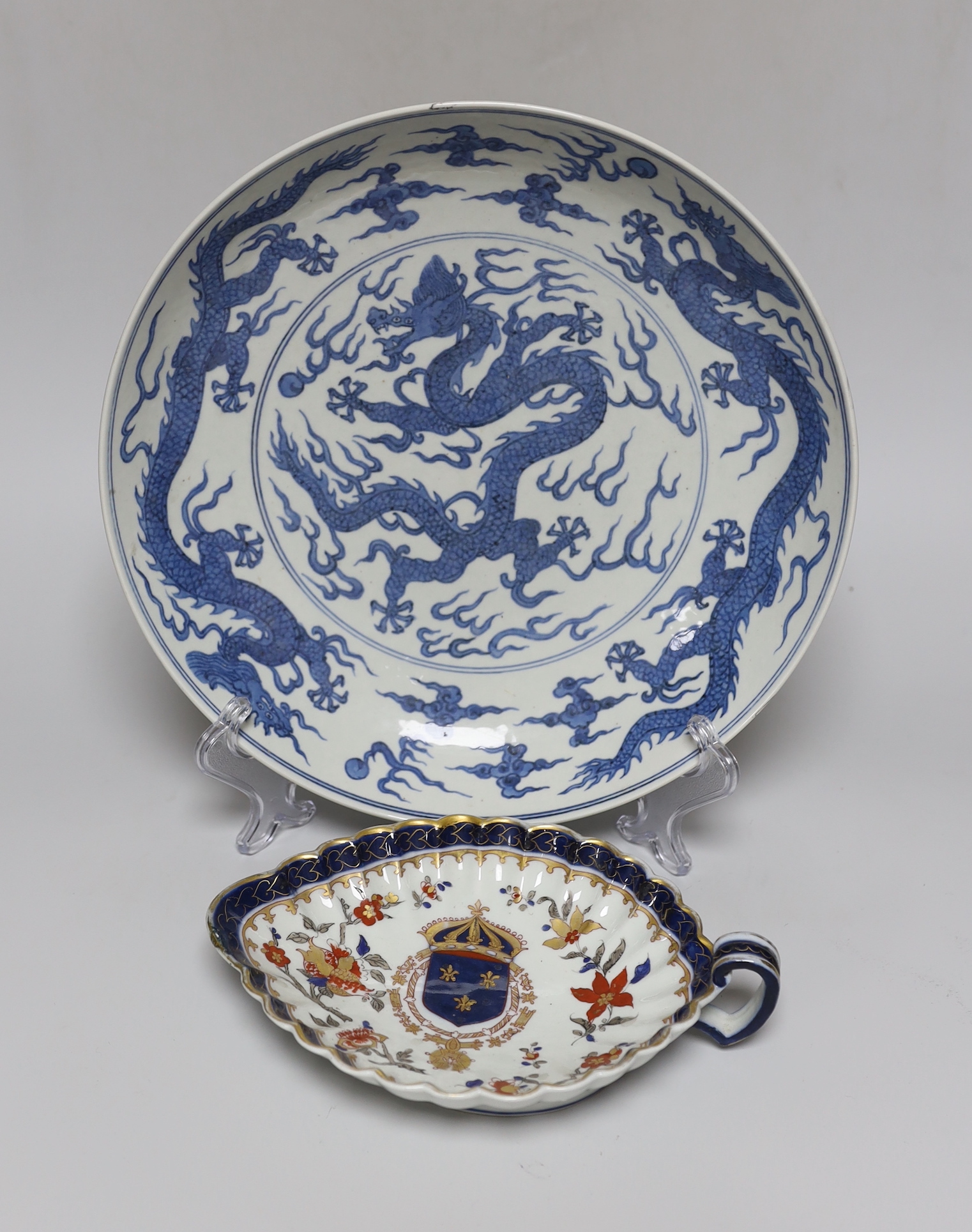 A Chinese blue and white ‘dragon’ dish, marked to base, 28cm diameter, together with a Samson blue and white ground serving dish with gilt decoration